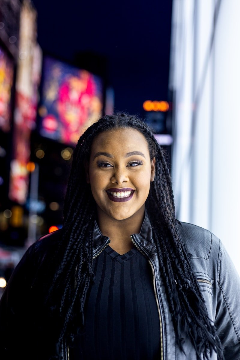 a woman with dreadlocks standing in front of a building